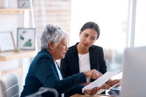 2 women pointing at a report