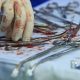 bloodstained surgical instruments and surgeon's hand in bloody glove taking clamp close-up
