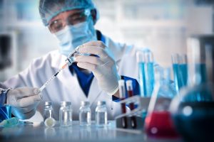 Virologist filling a syringe researching vaccine in laboratory bench. Horizontal composition. Front view.