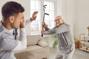 Angry,Elderly,Senior,Man,Going,To,Hit,Young,Male,Caregiver