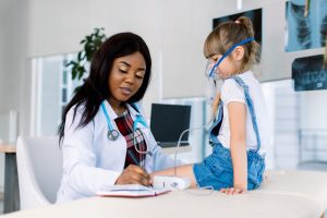 Young,African,Female,Doctor,Helping,To,Little,Girl,With,Nebulizer