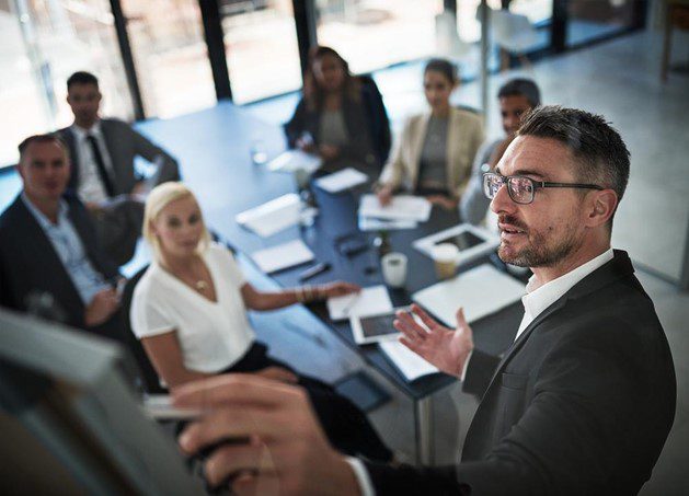 Business meeting where business man is pointing at a monitor