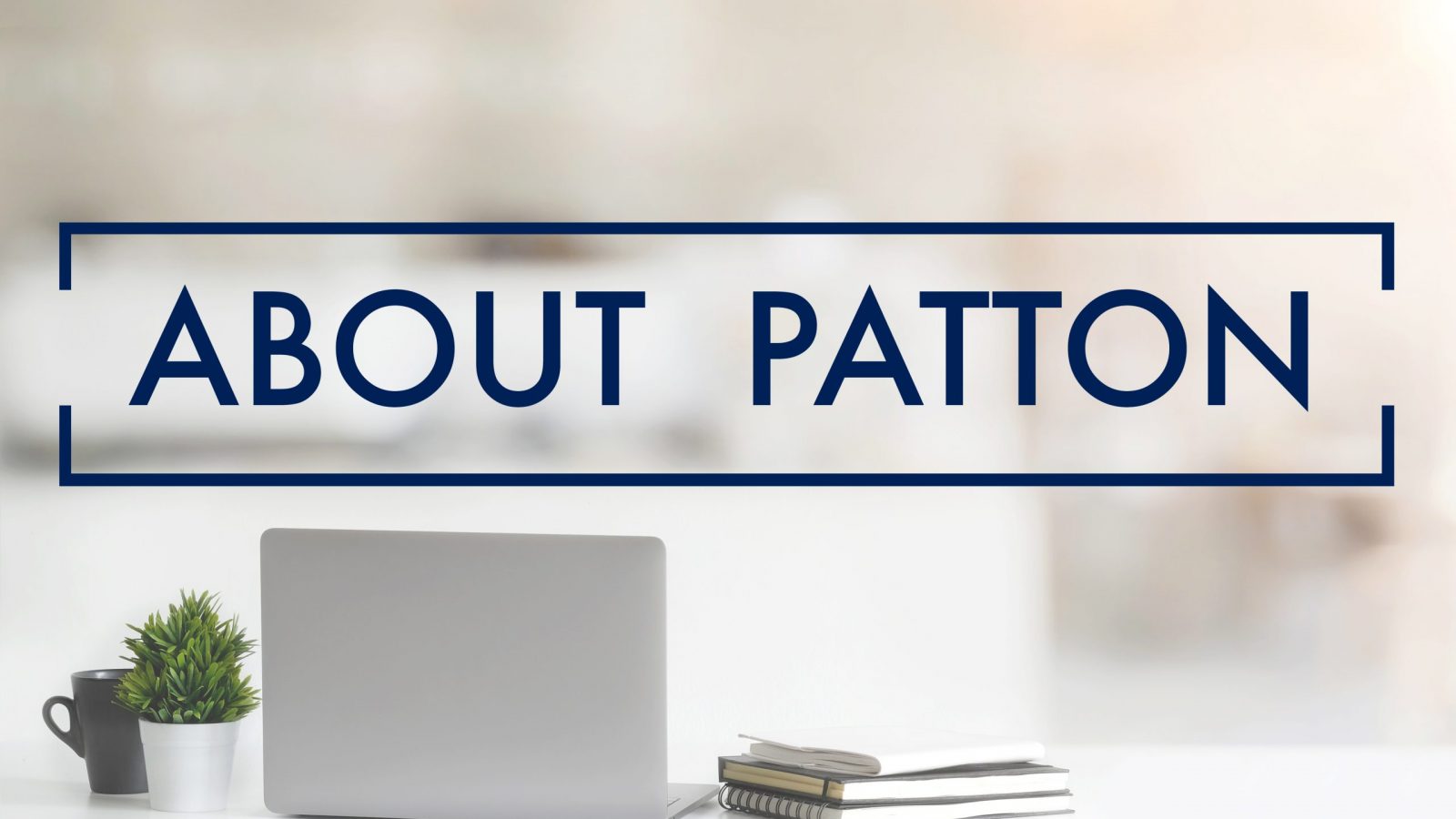 Close up view of simple workspace with laptop, notebooks, coffee cup and tree pot on white table with blurred office room background with the words "About Patton" in the foreground"