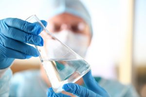 Male,Scientist,Hold,In,Arm,Empty,Vials,Closeup.,Chemical,Lab