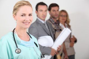 Female,Nurse,Stood,Next,To,Four,Professionals,From,Different,Backgrounds