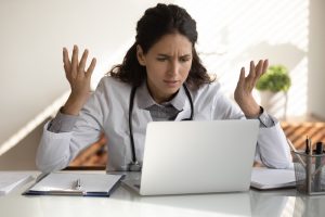 Angry,Female,Nurse,Work,On,Laptop,In,Clinic,Frustrated,By