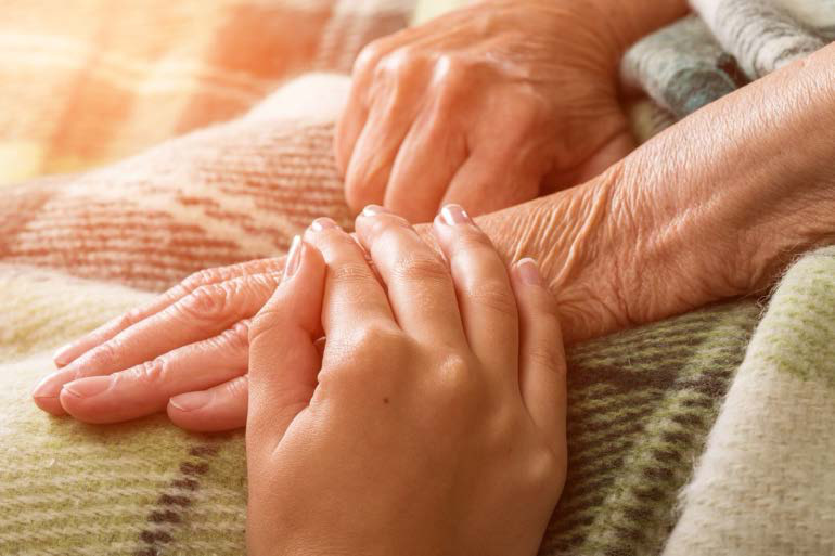 Hands of a caregiver and patient