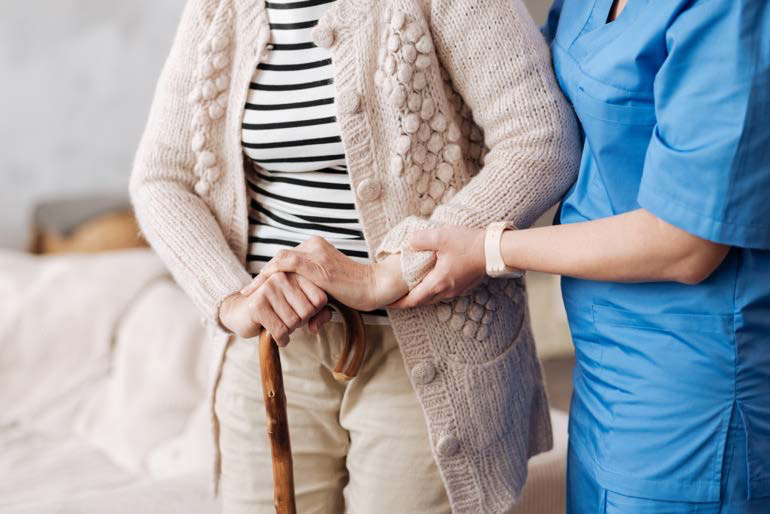 Home health aide assisting an older patient