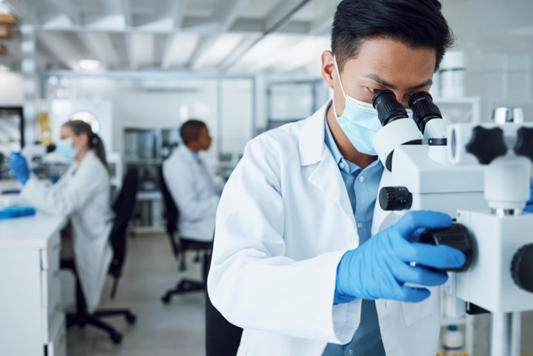Laboratory professional using a microscope