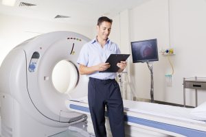 Young,Doctor,Standing,In,Front,Of,An,Mri,Scanner