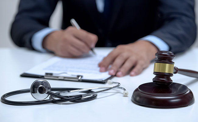 Judge signing arrest warrant for medical error, banging gavel near stethoscope