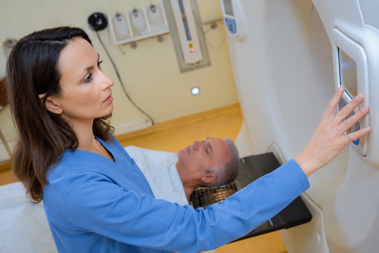 MRI technologist assisting a patient during an MRI examination