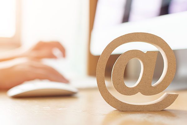 E-mail marketing concept, Hand using computer sending message with wooden email address symbol