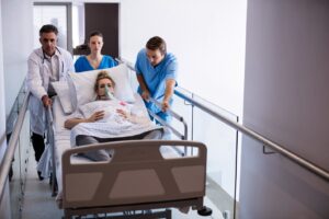 pregnant women being wheeled in a hospital bed down the hallway